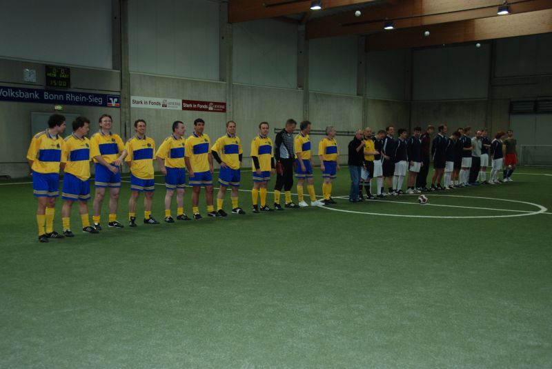 Die Mannschaften vor Spielbeginn. Die Ehemaligen präsentieren sich in gelb-blau.