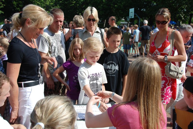 Die Paten versehen die neuen Schülerinnen und Schüler mit Bändchen, mit denen sie ihre Mitschüler finden.