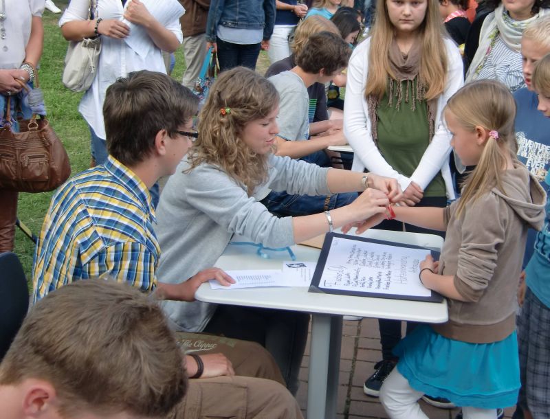 Mit Farbbändern bringen die Paten jeden Sextaner zu seiner Klasse.